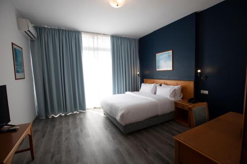 a hotel room with a bed and a large window at El Sheikh Suites Hotel in Beirut