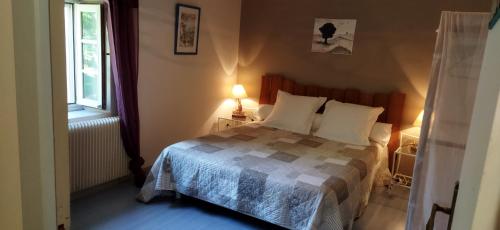 a bedroom with a bed and a window at La Maison des Escargots in Blanzay