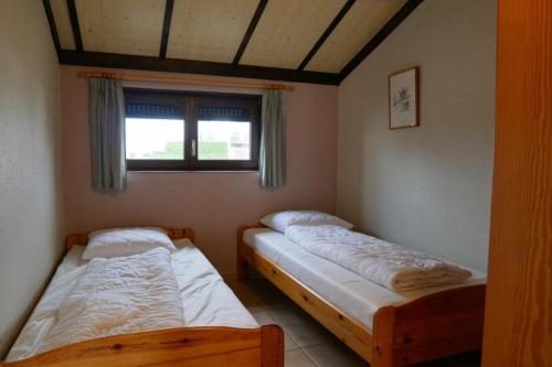 2 camas individuales en una habitación con ventana en Zeepolder III 157, en De Haan
