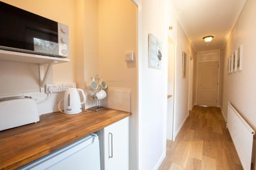 a kitchen with a counter top and a microwave at Cosy Annex, Close to Beach with Parking in Torquay