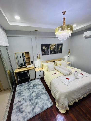 a bedroom with two beds and a chandelier at KITJA MY HOME in Hat Yai