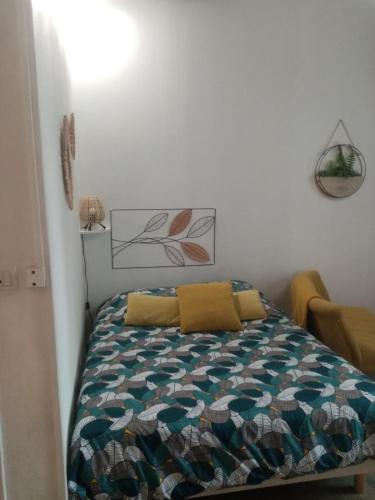 een slaapkamer met een bed met een quilt bij les amandiers in Tours