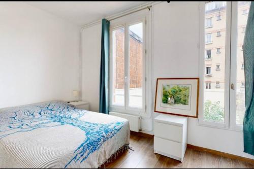 a bedroom with a bed and two windows at Maison / Porte de Versailles in Vanves