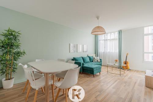 a living room with a table and a green couch at R 'AppartsT3 Serenity Haven in Torcy