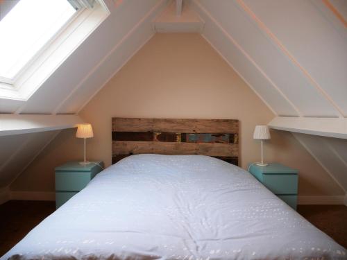a bedroom with a bed and two night stands at Zeepolder I 45 in De Haan