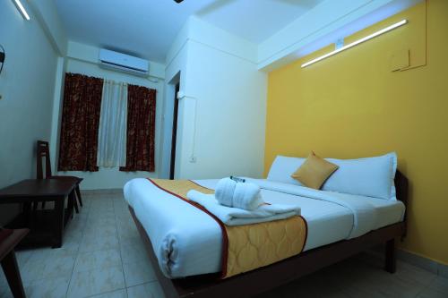 a bedroom with a bed and a table and a window at Hotel Gamas Inn in Chacka