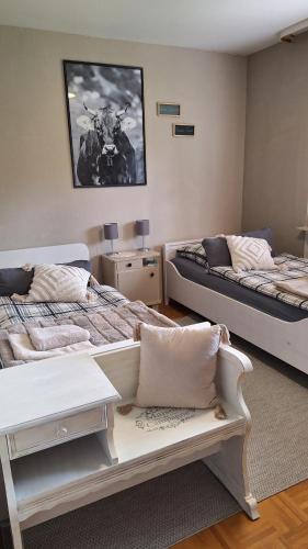 Un dormitorio con 2 camas y un banco. en Ferienhaus Hinterlandswald, en Schlangenbad