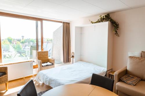 um quarto com uma cama e uma grande janela em May Fair 0412 em De Haan