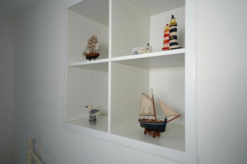 une étagère avec un voilier jouet sur elle dans l'établissement Cranny Cottage Carnlough, à Carnlough