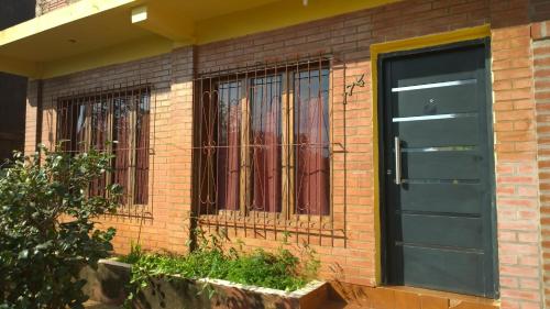 un edificio de ladrillo con una puerta y ventanas negras en Yate I en Puerto Iguazú