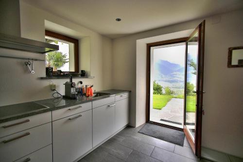 a kitchen with a door leading to a patio at La Stalla in Magadino