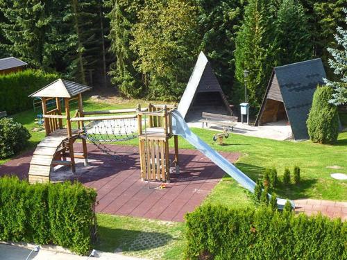 einen Spielplatz mit Rutsche in einem Park in der Unterkunft Naturerlebnisdorf Blauvogel 6 in Hasselfelde