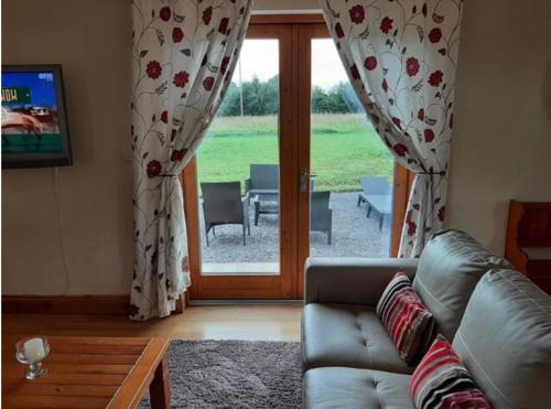 a living room with a couch and a sliding glass door at The Lake House Apartment in Drumshanbo