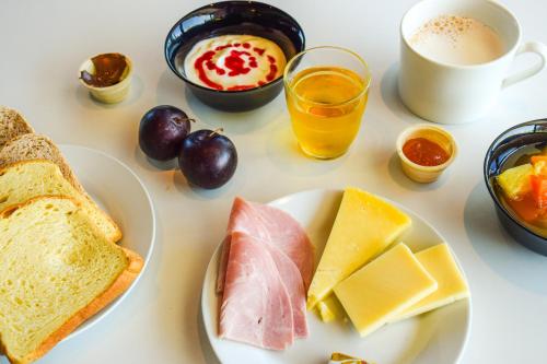 una mesa con un plato de queso y pan y una taza de café en ibis budget Rodez, en Rodez