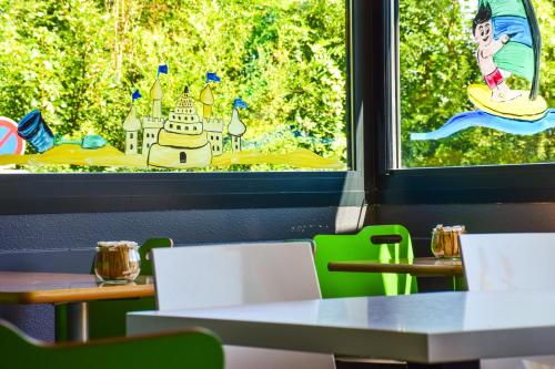 a room with tables and a window with a view at ibis budget Rodez in Rodez