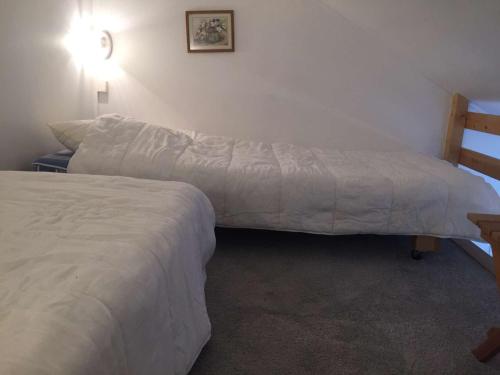 - une chambre avec deux lits, une table et un lit dans l'établissement Studio Mezzanine 4 Pers, Proche Pistes et Commerces, Balcon Est, Animaux Bienvenus - FR-1-330-530, à Risoul