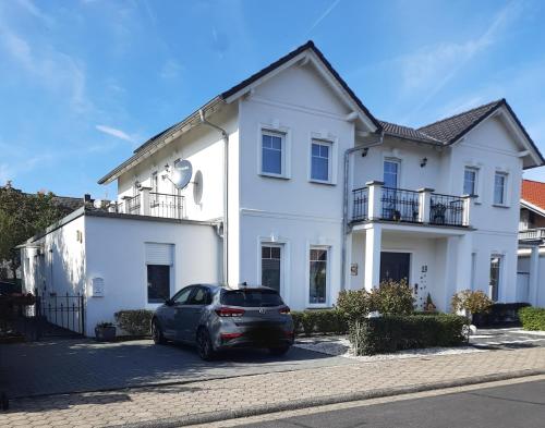 ein weißes Haus mit einem Auto vor dem Haus in der Unterkunft Villa Bianca - Holiday & Business in Elsenfeld