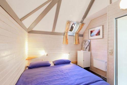 1 dormitorio con 1 cama azul en una habitación en Lass-deine-Seele-baumeln-in-der-Natur-im-Ferienhaus-Felix-von-Mein-Seepark, en Kirchheim