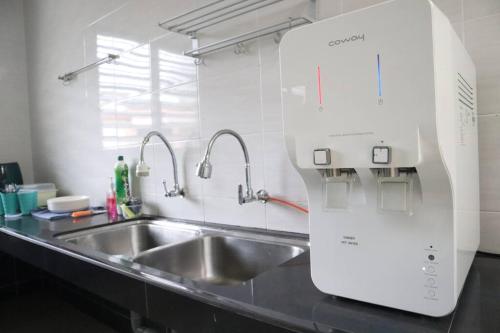 a kitchen counter with a sink and a microwave at Green Space Homestay Cozy Family(8-12pax) in Ipoh