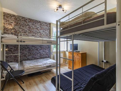 une chambre avec deux lits superposés et un bureau dans l'établissement Appartement spacieux à Gourette, 8 pers, 2 ch, entrée station, bien équipé, casier à skis - FR-1-400-113, à Eaux-Bonnes