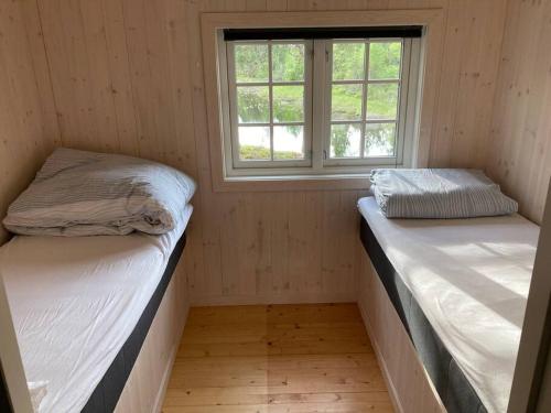 twee bedden in een kleine kamer met een raam bij Svingom - hytte uten strøm og vann 