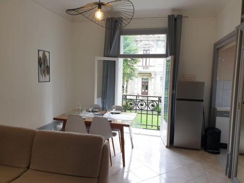 un salon avec une table et des chaises et une fenêtre dans l'établissement Grand T2 calme et cosy au « Pyrénées Palace », à Luchon