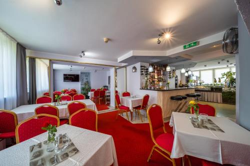 a restaurant with tables and chairs and a bar at Hotel Gromada Poznań in Poznań