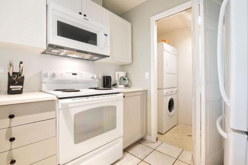 a white kitchen with a stove and a microwave at Whistler Vacation Club at NorthStar in Whistler