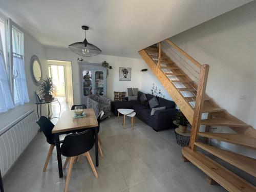 uma sala de estar com uma escada e um sofá em Maison chaleureuse avec terrasse privative proche de la gare em Rochefort