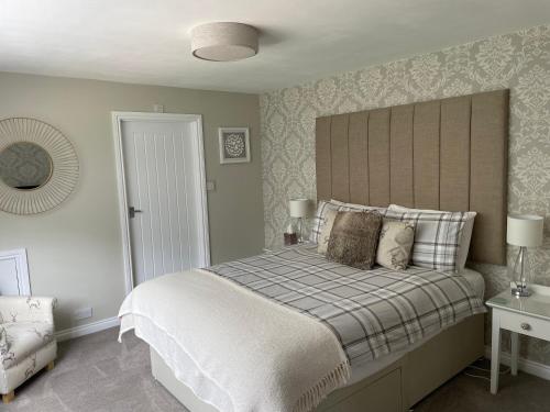 a bedroom with a large bed with a large headboard at Woodland House B & B in Wimborne Minster