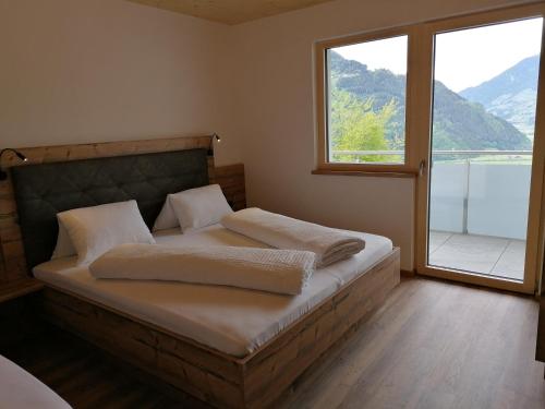 a bedroom with a bed with a large window at Montepart Zillertal in Hainzenberg