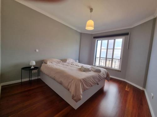 a bedroom with a bed and a large window at Olimpia Gardens View by Rentallido in São Gonçalo