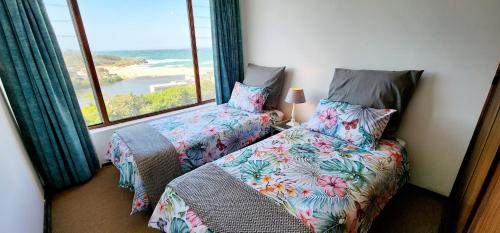 two beds in a room with a view of the ocean at Claridge Heights 305 – Sleeps 5 - Accross from Ramsgate’s main Blue Flag swimming beach in Margate