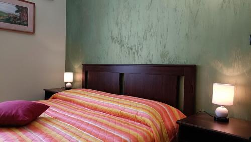 トリノにあるLA QUALITA' AL QUADRATOのベッドルーム1室(ベッド1台、ナイトスタンド2台、ランプ2つ付)