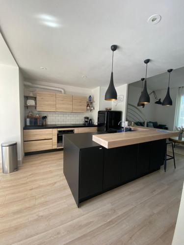 a kitchen with a black island in a room at Saint Charles in Orléans