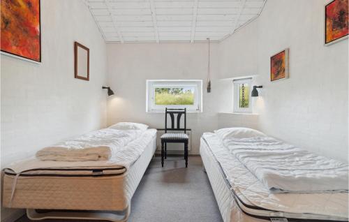 2 Betten in einem Zimmer mit einem Tisch und einem Stuhl in der Unterkunft Pet Friendly Home In Thisted With Wifi in Torsted