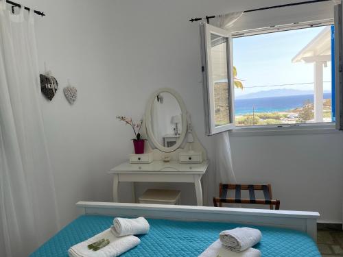 a bathroom with a mirror and two towels on a bed at Venus Myconian Residences in Kalafatis