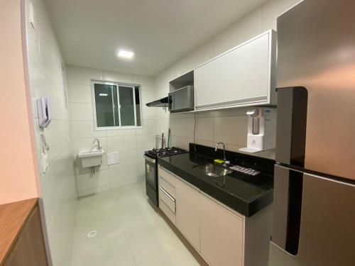 una cucina con bancone nero e lavandino di Edifício Promenade II Apt 303- Mandi Hospitalidade a Maceió