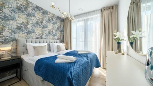 una camera da letto con un grande letto con una coperta blu di Apartamenty Sun & Snow Villa Solny a Ustronie Morskie