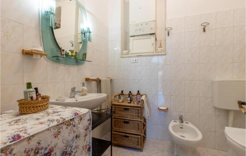 a bathroom with a sink and a toilet and a mirror at Awesome Apartment In Castelvecchio Pascoli With Wifi And 2 Bedrooms in Castelvecchio Pascoli
