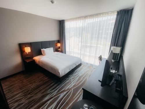 um quarto de hotel com uma cama e uma janela em IIP Apartments em Spreitenbach