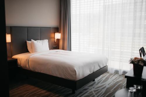 a bedroom with a bed and a large window at IIP Apartments - Self Check-In in Spreitenbach