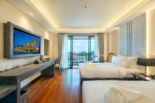 a hotel room with two beds and a television at Treepana Boutique Hotel, Huahin in Hua Hin