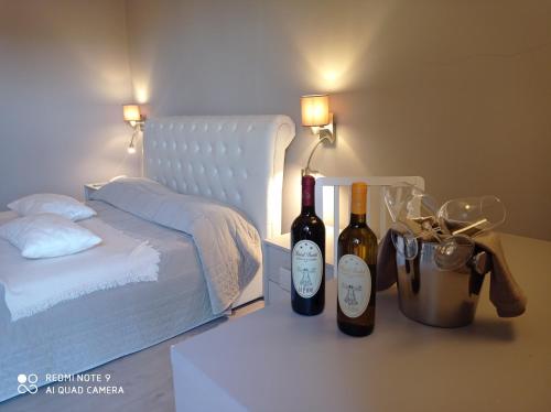 a bedroom with a bed and two bottles of wine at Hotel Monti in Lamporecchio