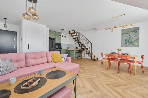 salon z różową kanapą i stołem w obiekcie Spacious Family Apartment with FREE GARAGE by Renters we Wrocławiu