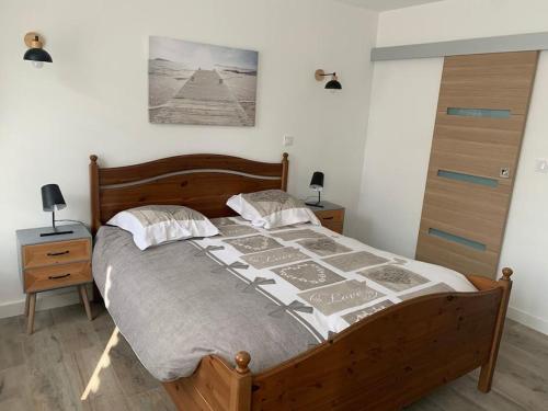 um quarto com uma cama de madeira e duas mesas de cabeceira em L havre de paix em Avelin