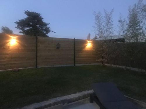 a backyard with a fence with lights on it at L havre de paix in Avelin