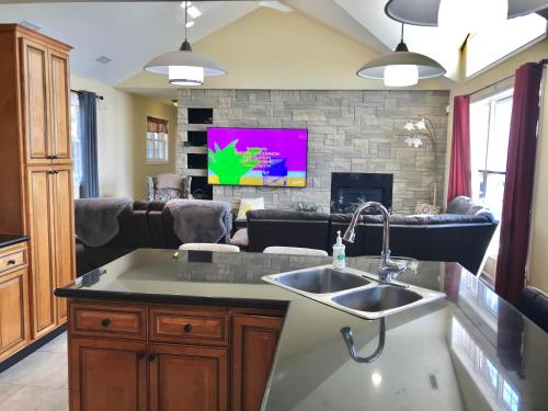 a kitchen with a sink and a living room at Happy vacation home by Erie lake in Kingsville
