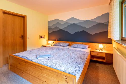 ein Schlafzimmer mit einem Bett mit einem Wandbild der Berge in der Unterkunft Ruheoase in Eisenbreche