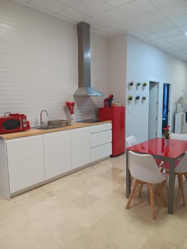 a kitchen with a table and a red refrigerator at Apartamentos Tierra Bobal in Requena
